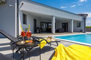 a patio with a table next to a swimming pool at Villa Speranza with Illuminated Pool in Pula