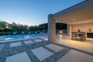 a patio with a table and chairs and a swimming pool at Villa Silentio in Marčana