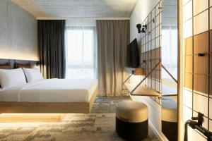 a hotel room with a bed and a window at Moxy Hamburg - Finkenwerder in Hamburg