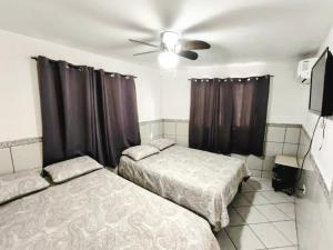 a bedroom with two beds and a ceiling fan at Casa Tecalai 5 in San Carlos