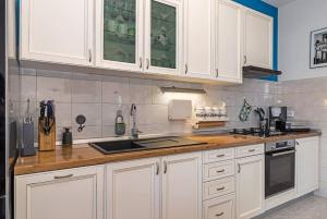 a kitchen with white cabinets and a sink at Rural Holiday Home Endi in Lozovac