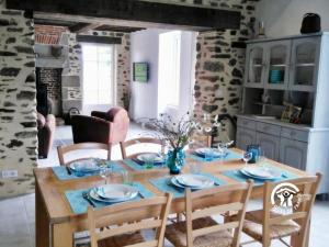 a dining room with a wooden table and chairs at La petite vallée in Saint-Calais-du-Désert