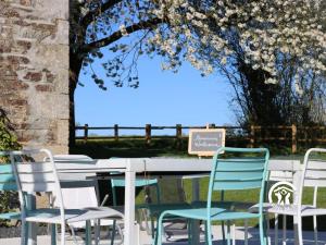 a group of chairs and a table with a sign at La petite vallée in Saint-Calais-du-Désert