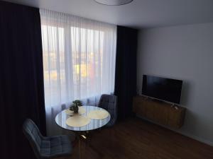 a living room with a table and a television at Itaja apartment 73 in Šiauliai