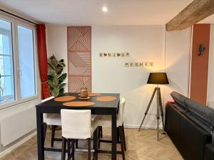 a dining room with a black table and chairs at Le Domus Pesmois in Pesmes