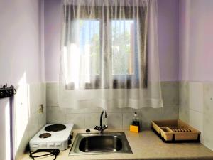 a kitchen counter with a sink and a window at Kapases Studios & Apartments in Peroulades +75 photos