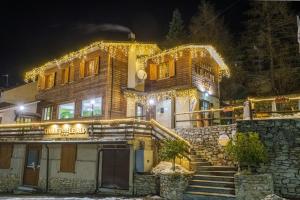 a house with christmas lights on the side of it at Chalet Le Alpi - Azzurro Club in Prato Nevoso