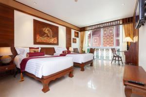 Una habitación de hotel con dos camas y un televisor. en Kodchasri Thani Hotel Chiangmai, en Chiang Mai 64 fotos más