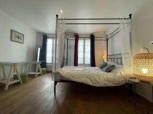 a bedroom with a canopy bed in a room at Appt 3 pièces LA ROCHELLE - LR180-030 in La Rochelle