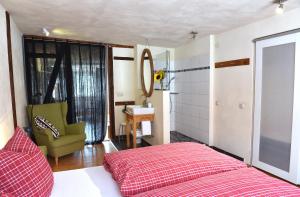 a bedroom with a red bed and a green chair at Apartmenthaus Duderstadt in Duderstadt