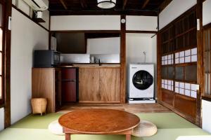 a kitchen with a wooden table in a room at 民泊つぎとはぎ in Miura