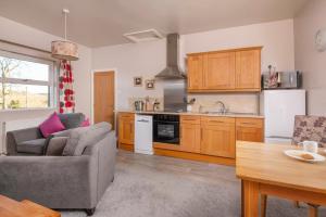 a living room with a couch and a kitchen at Sharp Edge in Penrith
