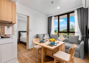 a kitchen and living room with a table and a couch at Laguna Skypark by My Home Phuket in Bang Tao Beach