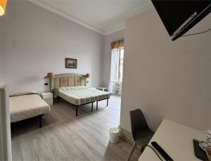 a room with two beds and a table at Hotel Ely in Viareggio