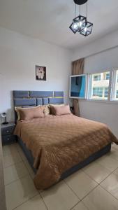 a bedroom with a large bed with a brown comforter at Reem 1 in Ajman 