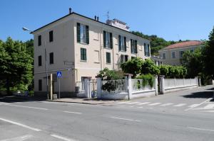 un edificio blanco con una valla al lado de una calle en Albergo Belvedere, en Acqui Terme