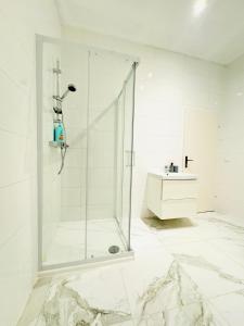 a white bathroom with a shower and a sink at Comfortable 5BR Shared Apt 10 Minute Walk to Matzleinsdorfer Platz in Vienna