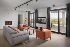 een woonkamer met een bank en stoelen en een open haard bij Luxury villa Arman with whirlpool in Visinada in Vranje Selo