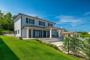 een wit huis met een groen gazon bij Luxury villa Arman with whirlpool in Visinada in Vranje Selo