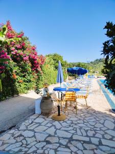 a patio with a table and chairs and umbrellas at Kapases Studios & Apartments in Peroulades