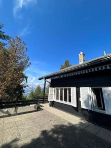 una casa con persiane bianche sul lato di Cache-Cache MOUNTAIN & QUIET chalet 10 pers a Veysonnaz