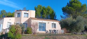 a white house with two chairs in front of it at Maison rénovée avec terasse et jardin privé, aéroport et Aix-en-Provence à 15 minutes in Velaux