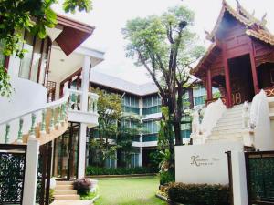 a large building with stairs and a building at Kodchasri Thani Hotel Chiangmai in Chiang Mai