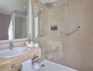 a bathroom with a sink and a glass shower at Meliá Cala Galdana in Cala Galdana