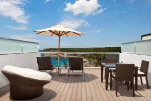 a patio with an umbrella and a table and chairs at Meliá Cala Galdana in Cala Galdana