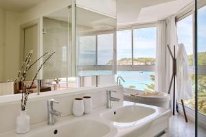 a bathroom with two sinks and a large mirror at Meliá Cala Galdana in Cala Galdana