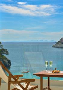 a table with two glasses of wine and a chair at Meliá Cala Galdana in Cala Galdana