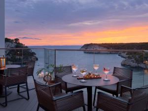 a patio with a table with glasses of wine at Meliá Cala Galdana in Cala Galdana