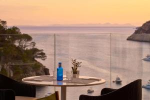 a table with a blue bottle sitting on top at Meliá Cala Galdana in Cala Galdana