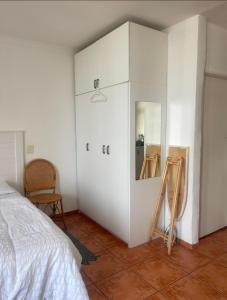 a bedroom with a white cabinet with a mirror at Atlantic 92 Regent in Cape Town