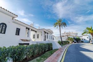 a white house with palm trees and a street at AB4 - vacation home, Marbella by Roomservices in Marbella