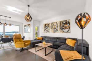 Una sala de estar con un sofá negro y una mesa. en Luxury Apartments Velic Brodarica, en Brodarica