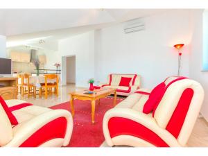 a living room with red and white chairs and a table at Villa Pletikosa in Brištane