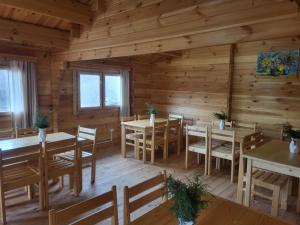a dining room with tables and chairs in a log cabin at Green Training Center HOVK in Dilijan