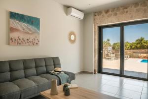 a living room with a couch and a sliding glass door at Petradi Villa Skala I in Skala