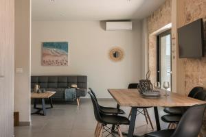 a living room with a table and chairs and a couch at Petradi Villa Skala I in Skala +86 photos