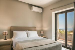 a bedroom with a bed with a view of the ocean at Petradi Villa Skala I in Skala