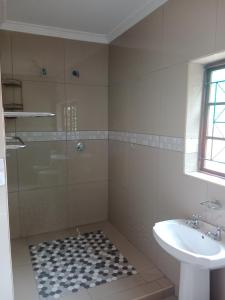un baño con ducha y lavabo en SNORING INN Mtubatuba, en Mtubatuba