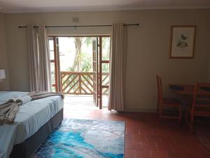 a bedroom with a bed and a door to a patio at SNORING INN Mtubatuba in Mtubatuba