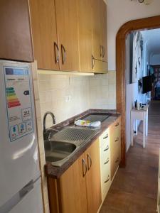 a kitchen with a sink and a refrigerator at Estudio luminoso, primera línea de playa de las canteras in Las Palmas de Gran Canaria
