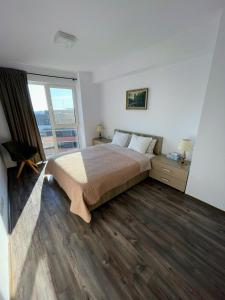 Un dormitorio con una cama y una ventana grande. en Panoramic View Timisoara, en Timisoara