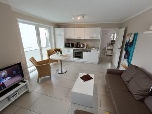 a living room with a couch and a table at Haus Nemo - Appartement 5, Gemütliches Appartement - Strandkorb, strandnah 50 m in Heringsdorf