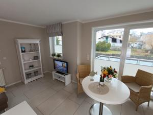 a living room with a table and a tv at Haus Nemo - Appartement 5, Gemütliches Appartement - Strandkorb, strandnah 50 m in Heringsdorf