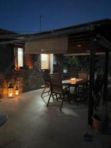 a patio with a table and chairs and a building at MANOLIS COTTAGE THANOS in Thános