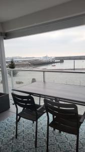 a table and chairs in a room with a view of the ocean at Appartement avec loggia vue mer port Maria in Quiberon