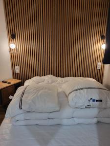 a large bed with white sheets and pillows on it at Appartement avec loggia vue mer port Maria in Quiberon